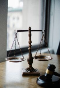 Bronze scales of justice balanced beside a gavel on a law office desk, symbolizing evidence to collect after accident cases