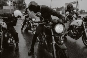 Group of motorcyclists on a rain-soaked road, illustrating the heightened risks that lead to motorcycle accidents