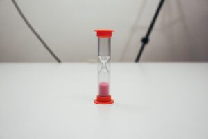 How long does a truck accident consultation take — small hourglass with pink sand on a white table