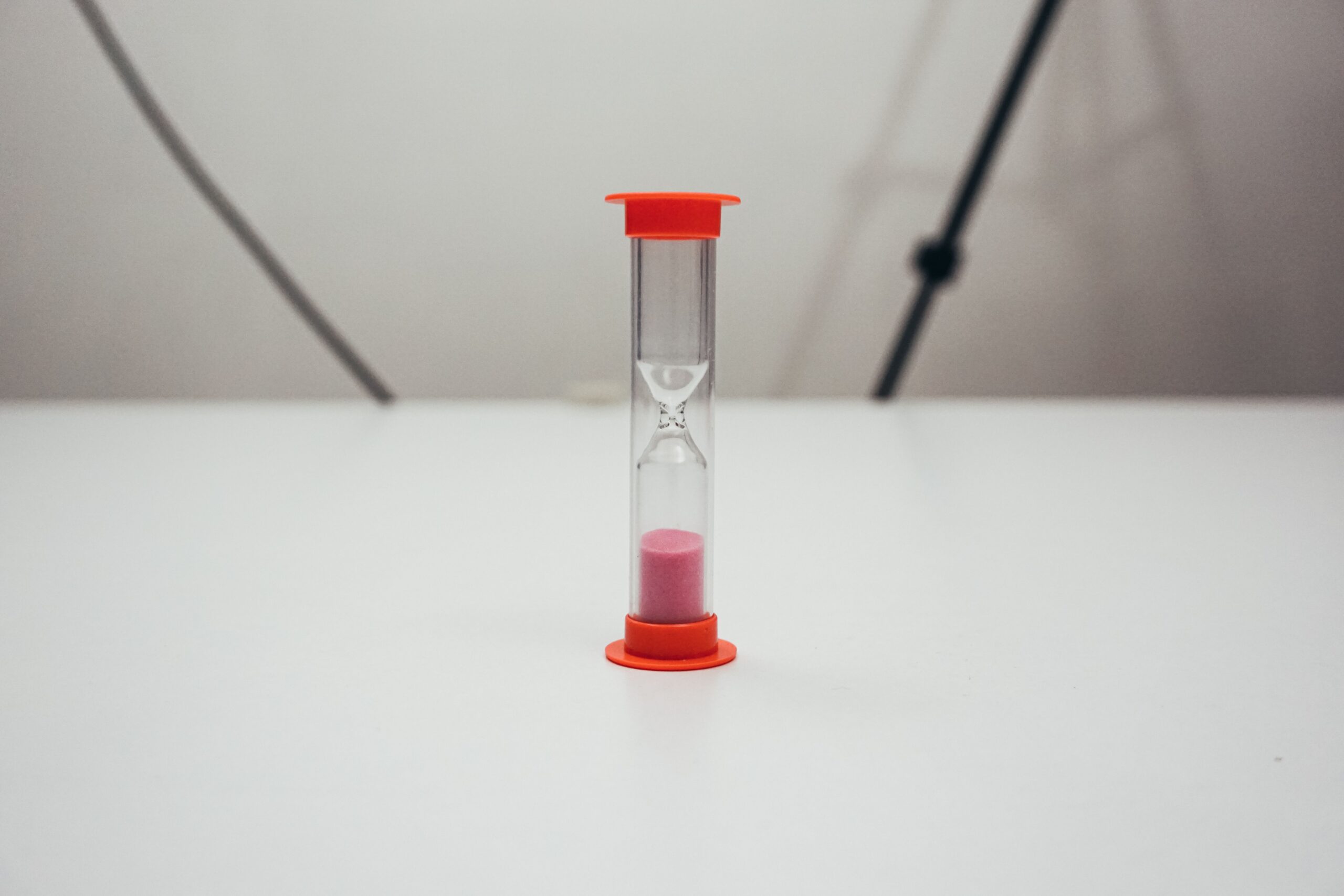 How long does a truck accident consultation take — small hourglass with pink sand on a white table