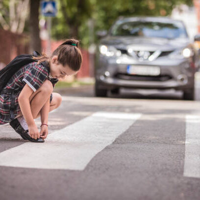 Cute girl in school uniform adjusting her socks on the way to school